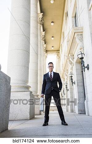 Mixed race businessman standing outside courthouse View Large Photo Image Picture - Mixed race businessman standing outside courthouse. Fotosearch
