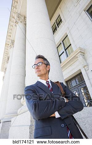Mixed race businessman standing outside courthouse View Large Photo Image Stock Image - Mixed race businessman standing outside courthouse. Fotosearch