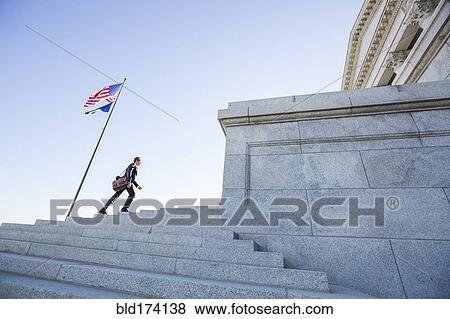 Stock Photo - Mixed race businessman walking on courthouse steps. Fotosearch