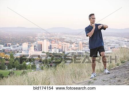 Mixed race man checking pulse on hilltop over Salt Lake City, Utah, United States View Large Photo Image Picture - Mixed race man checking pulse on hilltop over Salt Lake City, Utah, United States. Fotosearch