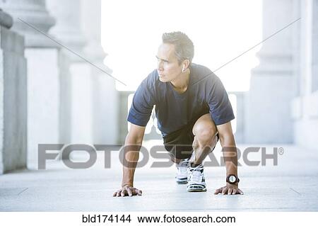Picture - Mixed race man stretching outside courthouse. Fotosearch