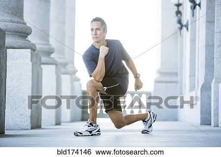 Stock Photograph - Mixed race man stretching outside courthouse. Fotosearch