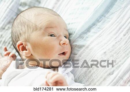 Stock Image - Mixed race newborn baby laying on blanket. Fotosearch
