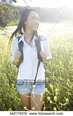 Mixed race woman carrying backpack in field View Large Photo Image Stock Image - Mixed race woman carrying backpack in field. Fotosearch