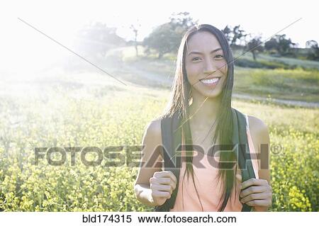 Mixed race woman carrying backpack in field View Large Photo Image Stock Photography - Mixed race woman carrying backpack in field. Fotosearch