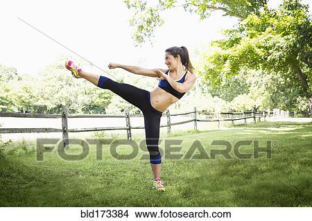Mixed race woman kicking in grass View Large Photo Image Picture - Mixed race woman kicking in grass. Fotosearch