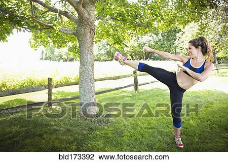 Mixed race woman kicking in grass View Large Photo Image Stock Image - Mixed race woman kicking in grass. Fotosearch