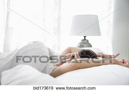 Stock Photo - Mixed race woman laying in bed. Fotosearch