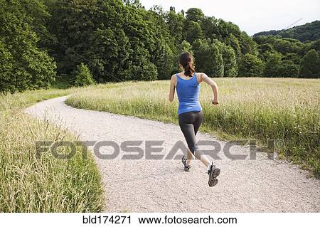 Stock Image - Mixed race woman running on path. Fotosearch