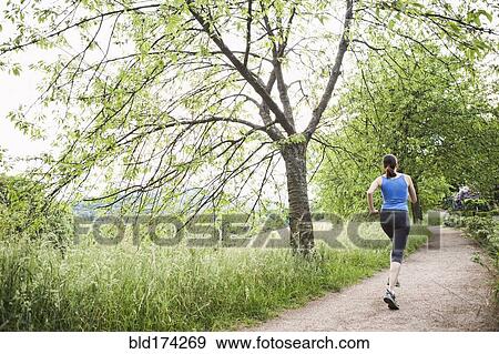 Stock Photo - Mixed race woman running on path. Fotosearch