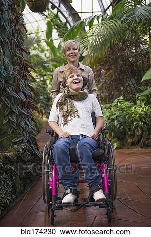 Mother pushing paraplegic daughter in wheelchair View Large Photo Image Stock Image - Mother pushing paraplegic daughter in wheelchair. Fotosearch