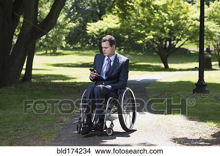 Picture - Paraplegic businessman in wheelchair in park. Fotosearch