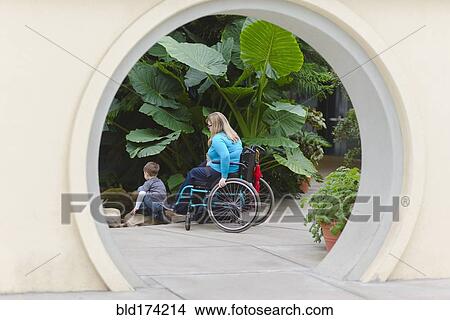 Picture - Paraplegic mother and son admiring plants. Fotosearch