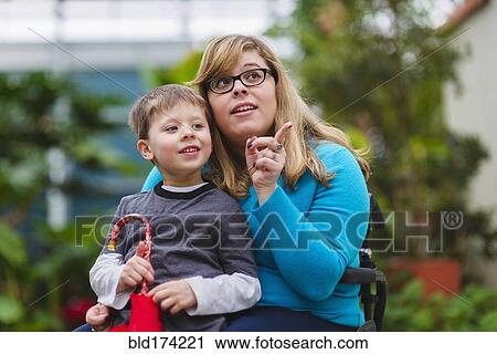 Stock Image - Paraplegic mother and son exploring outdoors. Fotosearch