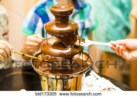 People eating from chocolate fountain View Large Photo Image Stock Photography - People eating from chocolate fountain. Fotosearch
