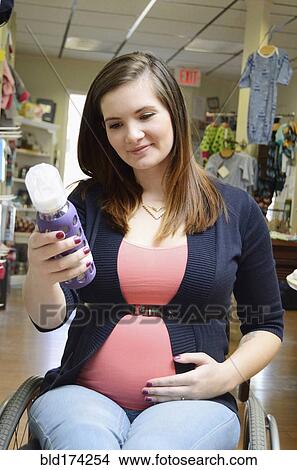 Pregnant paraplegic woman in wheelchair shopping in store View Large Photo Image Picture - Pregnant paraplegic woman in wheelchair shopping in store. Fotosearch