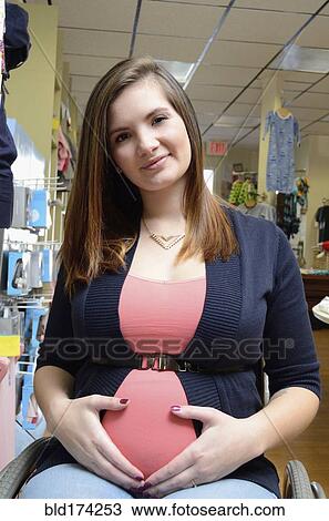 Pregnant paraplegic woman in wheelchair shopping in store View Large Photo Image Stock Image - Pregnant paraplegic woman in wheelchair shopping in store. Fotosearch