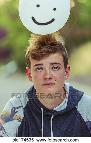 Stock Photography - Sad Caucasian teenage boy balancing balloon. Fotosearch