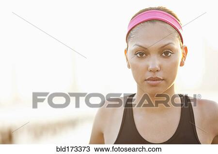 Stock Image - Serious Hispanic woman wearing headband. Fotosearch