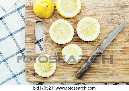 Sliced lemon on wooden cutting board View Large Photo Image Stock Image - Sliced lemon on wooden cutting board. Fotosearch