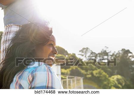 Stock Photo - Smiling woman sitting outdoors. Fotosearch