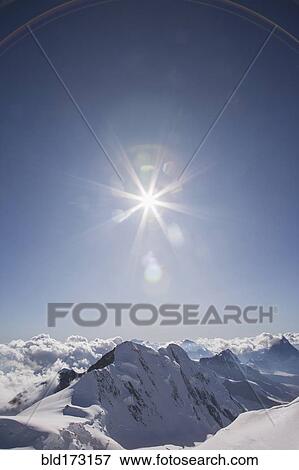 Sunshine over snowy mountaintops View Large Photo Image Stock Photo - Sunshine over snowy mountaintops. Fotosearch
