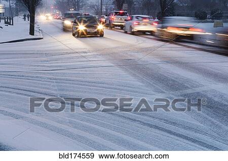 Stock Photo - Traffic driving on snowy street. Fotosearch