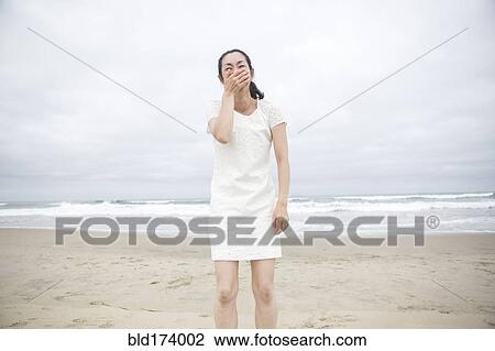 Woman laughing on beach View Large Photo Image Stock Image - Woman laughing on beach. Fotosearch