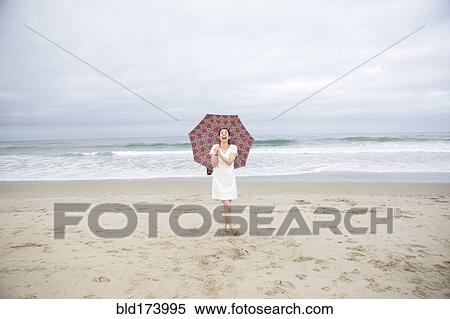 Woman laughing with umbrella on beach View Large Photo Image Stock Photography - Woman laughing with umbrella on beach. Fotosearch