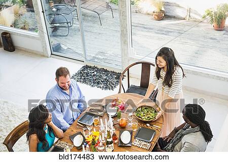 Woman serving friends at dinner party View Large Photo Image Stock Image - Woman serving friends at dinner party. Fotosearch