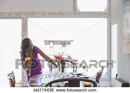 Stock Photograph - Woman setting dining table. Fotosearch