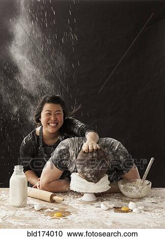 Woman shoving face of boyfriend in cake View Large Photo Image Stock Image - Woman shoving face of boyfriend in cake. Fotosearch