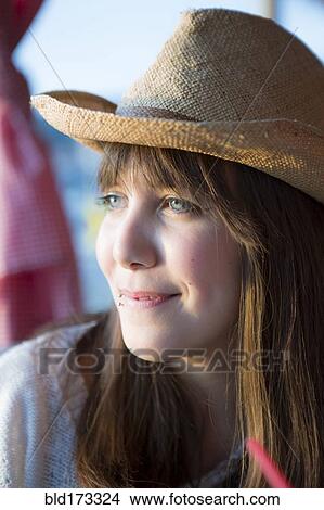 Picture - Woman wearing straw hat outdoors. Fotosearch