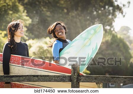 Women carrying surfboards outdoors View Large Photo Image Stock Image - Women carrying surfboards outdoors. Fotosearch