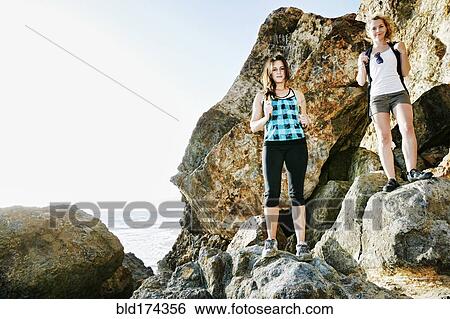 Stock Photograph - Women hiking on boulders. Fotosearch