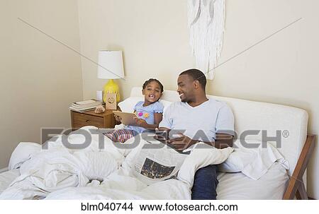 African American father and daughter sitting on bed View Large Photo Image Picture - African American father and daughter sitting on bed. Fotosearch