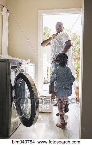 Picture - African American father and daughter doing laundry. Fotosearch