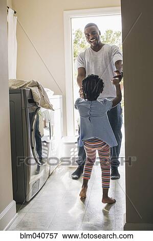 Stock Photo - African American father and daughter doing laundry. Fotosearch