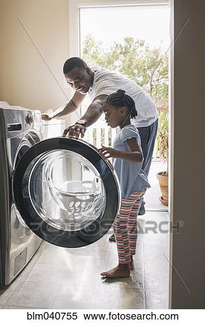 Stock Photography - African American father and daughter doing laundry. Fotosearch