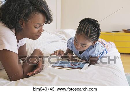 African American mother and daughter using digital tablet View Large Photo Image Stock Image - African American mother and daughter using digital tablet. Fotosearch