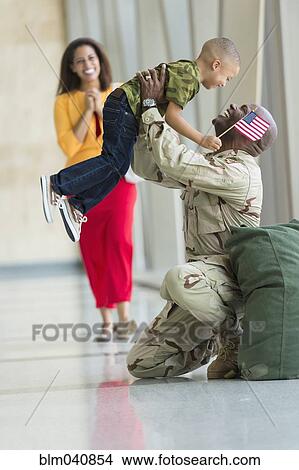 Picture - African American soldier greeting family in airport. Fotosearch