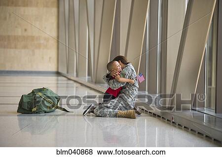 Stock Photo - African American soldier hugging son in airport. Fotosearch