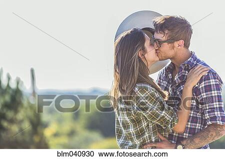 Stock Image - Caucasian couple kissing outdoors. Fotosearch