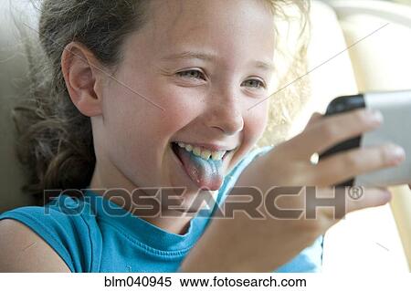 Caucasian girl with blue tongue taking selfie with cell phone View Large Photo Image Stock Photography - Caucasian girl with blue tongue taking selfie with cell phone. Fotosearch