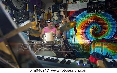 Stock Photo - Caucasian man playing drums in music studio. Fotosearch
