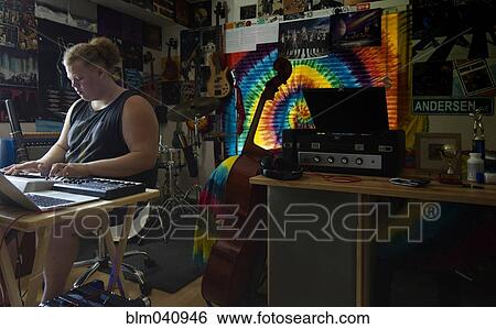 Stock Photograph - Caucasian man playing keyboard in music studio. Fotosearch