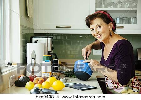 Picture - Caucasian woman cooking in kitchen. Fotosearch