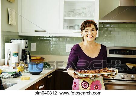 Caucasian woman cooking in kitchen View Large Photo Image Stock Image - Caucasian woman cooking in kitchen. Fotosearch