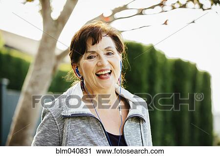 Caucasian woman listening to earbuds outdoors View Large Photo Image Stock Image - Caucasian woman listening to earbuds outdoors. Fotosearch