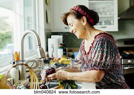 Caucasian woman washing vegetables in kitchen View Large Photo Image Picture - Caucasian woman washing vegetables in kitchen. Fotosearch